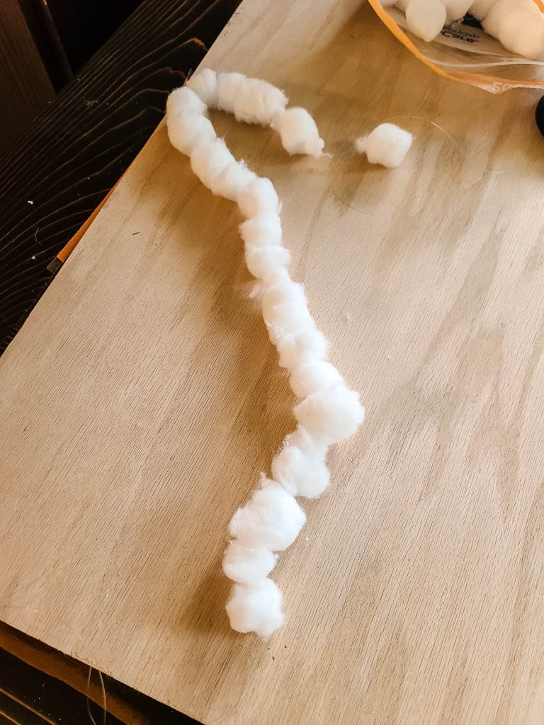 Cotton balls strung onto fishing line to make garland