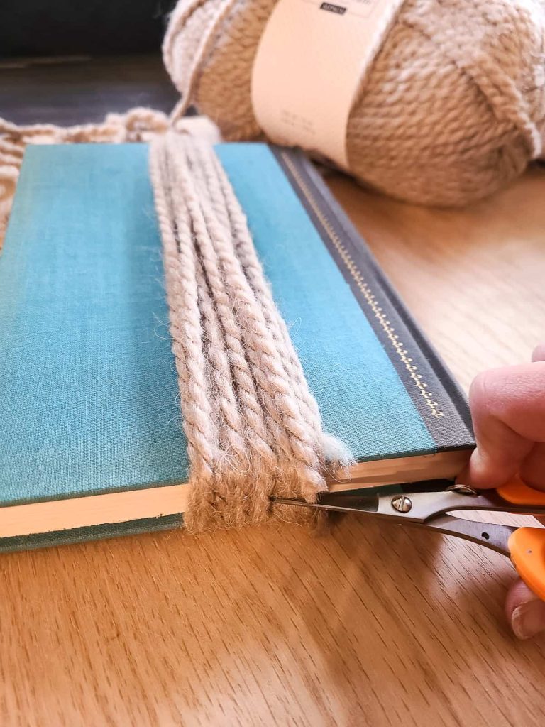 cutting yarn at the bottom to make a tassel