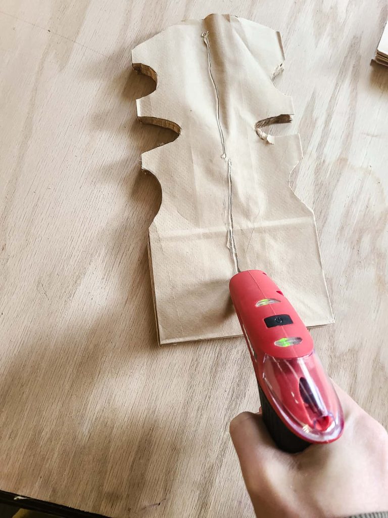 When you are done making each paper bag snowflake unique add a string of hot glue then get ready to open your paper bags