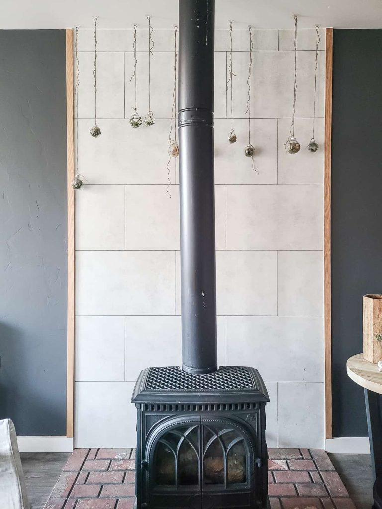 natural christmas ornaments hanging  from the ceiling behind old wood burning stove
