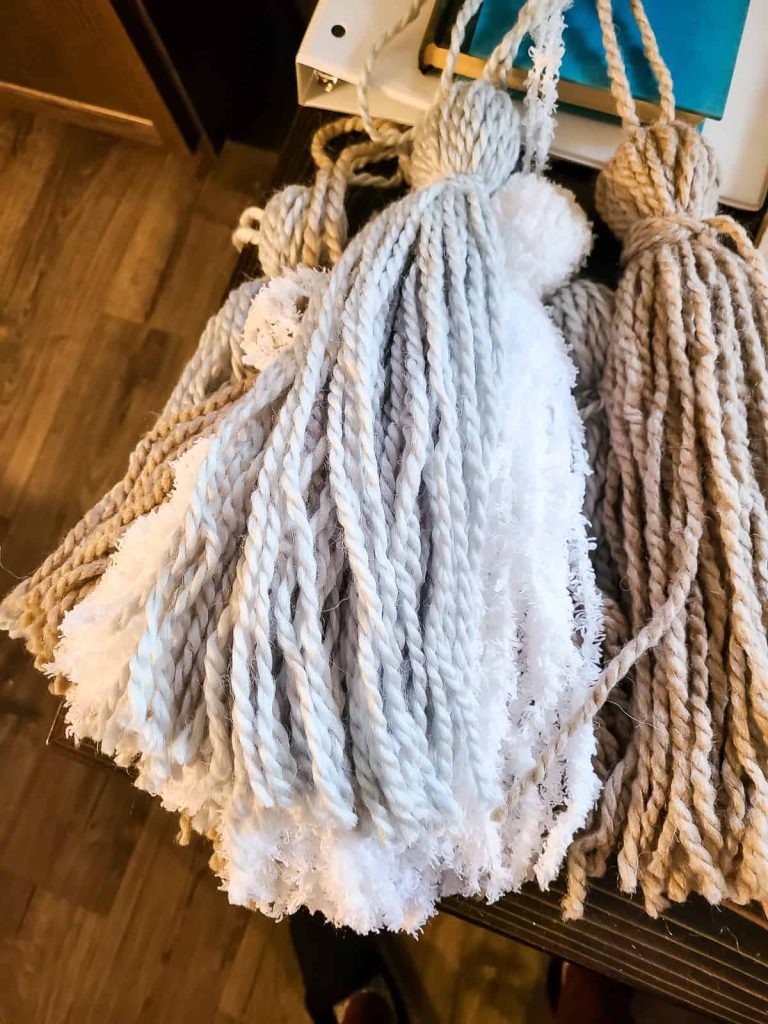 different sizes of yarn tassels laying in a pile 