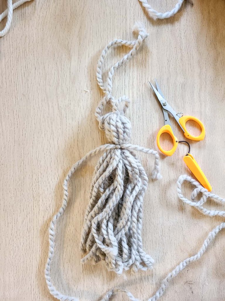 adding finishing touches to yarn tassel