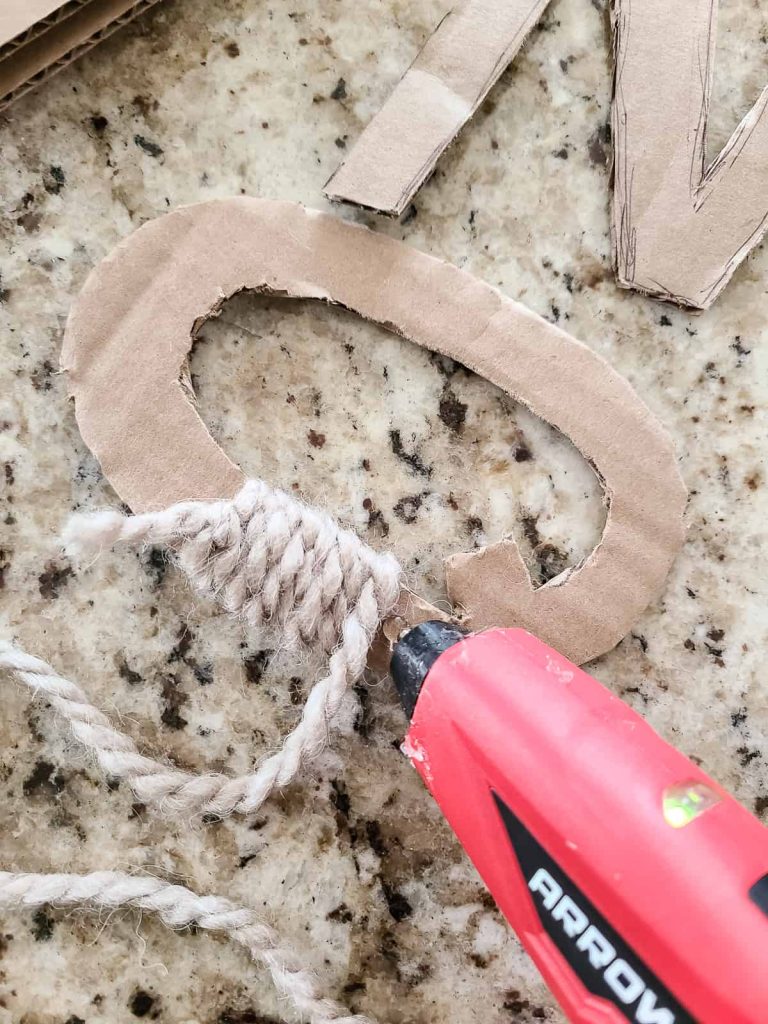 Continue wrapping the yarn around the cardboard cut out letter and secure with hot glue as you go 