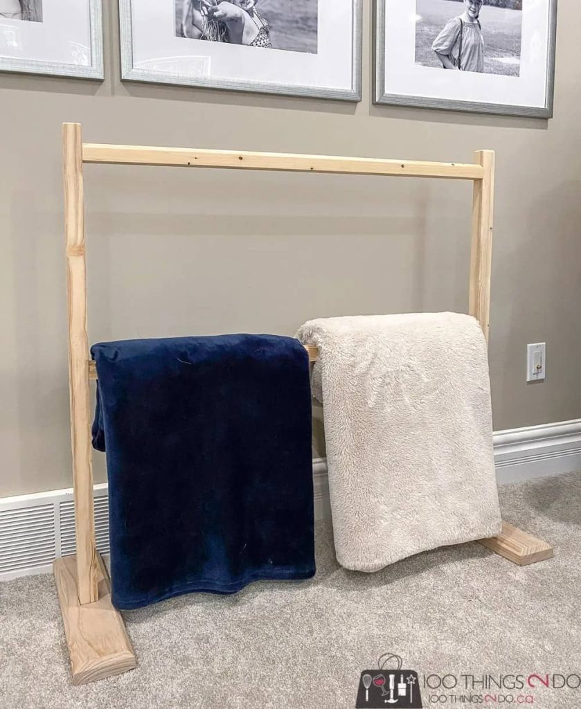 DIY blanket rack with two blankets on lower rung against the wall