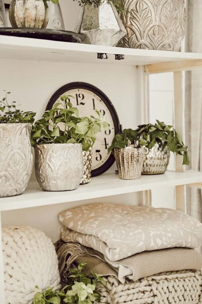 blankets stored on the bottom shelf of a bookcase