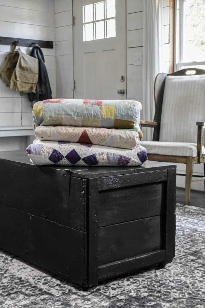 vintage trunk painted black and used for quilt storage