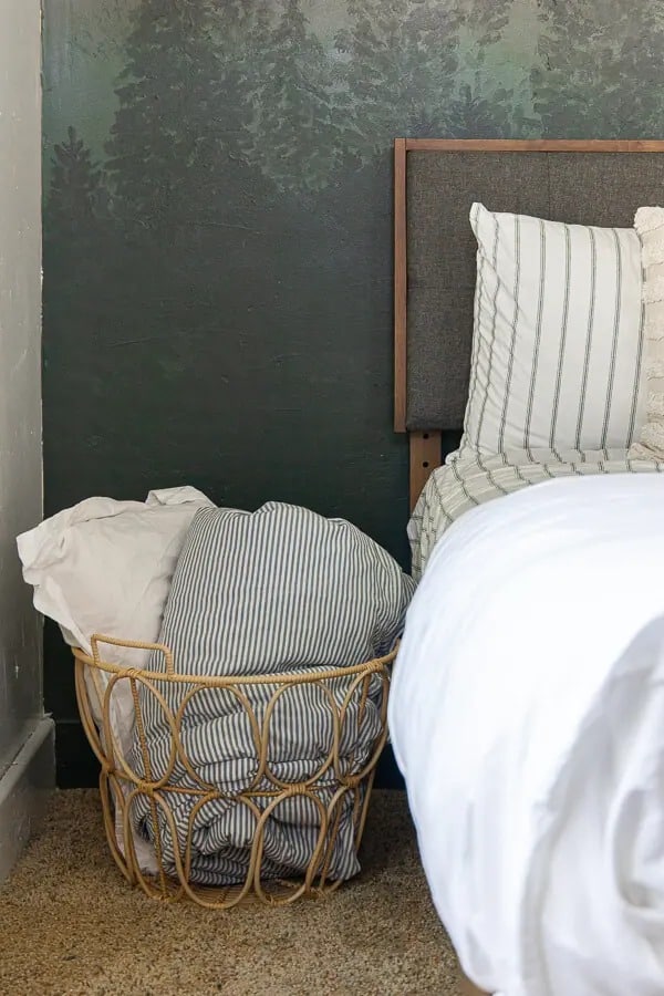 basket next to the bed for extra pillows or blankets