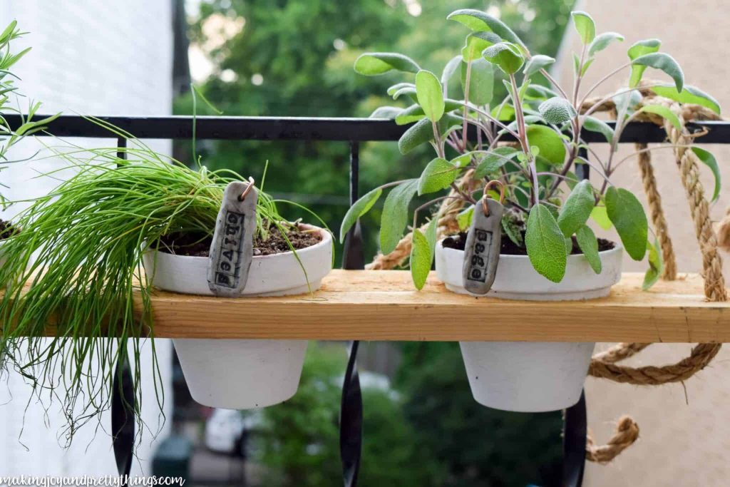 Make a mini herb garden to hang from your deck railing or balcony with scrap wood, rope and 4" planters 