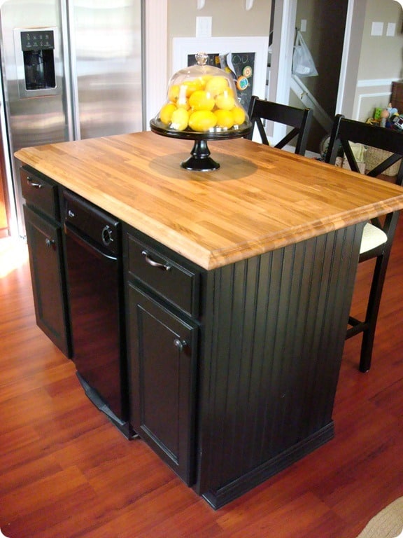 Small kitchen island with butcher block countertop with a dishwasher 