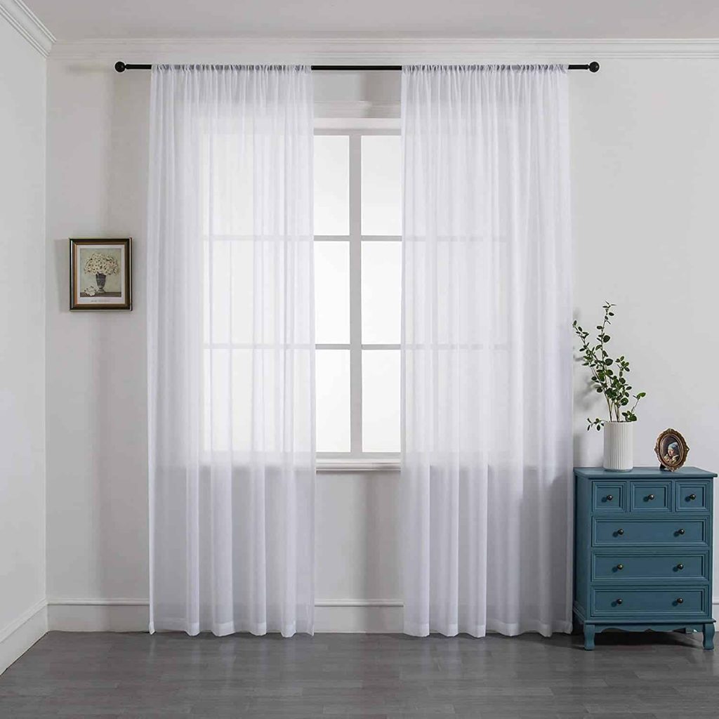 Get rid of heavy shades in the bedroom. It will feel much larger if you use light filtering shades, like the white curtain sheers.