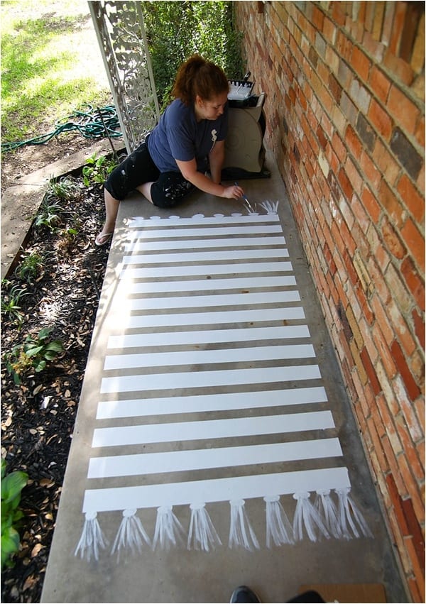 No money to buy a new outdoor rug for your patio? Paint a faux rug on the concrete or deck!
