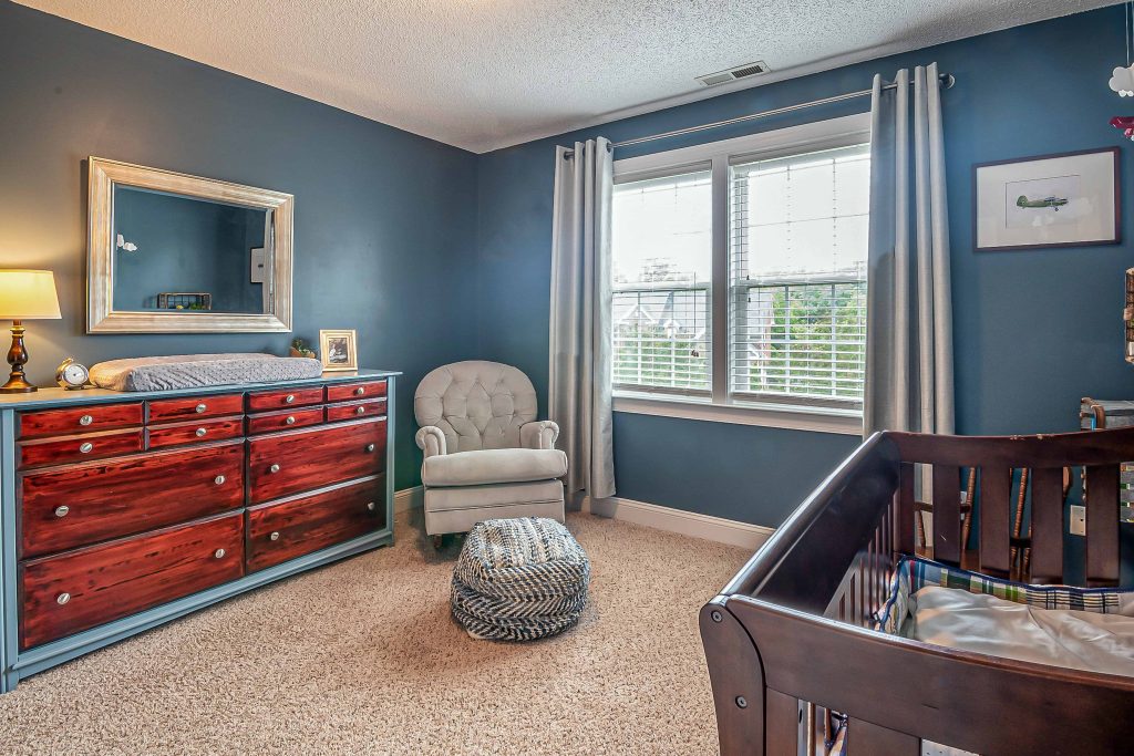 Nothing says a boy like a blue color on the walls in your nursery bedroom with a rocking chair and red accent dresser