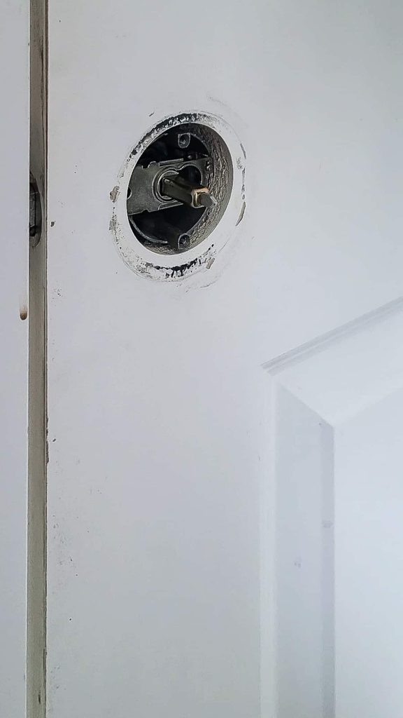 View of removed door knob and interior guts to replace with brand new door handles