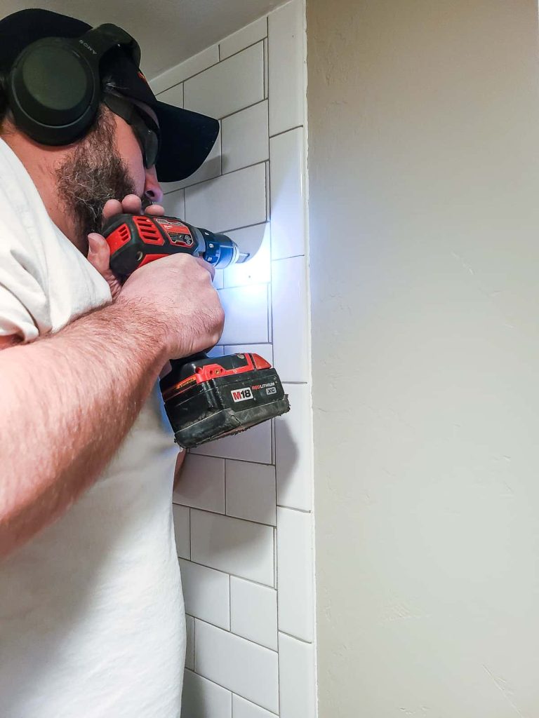 Wearing safety glasses in order to prevent chips from flying into your eyes when using a diamond bit to drill tile