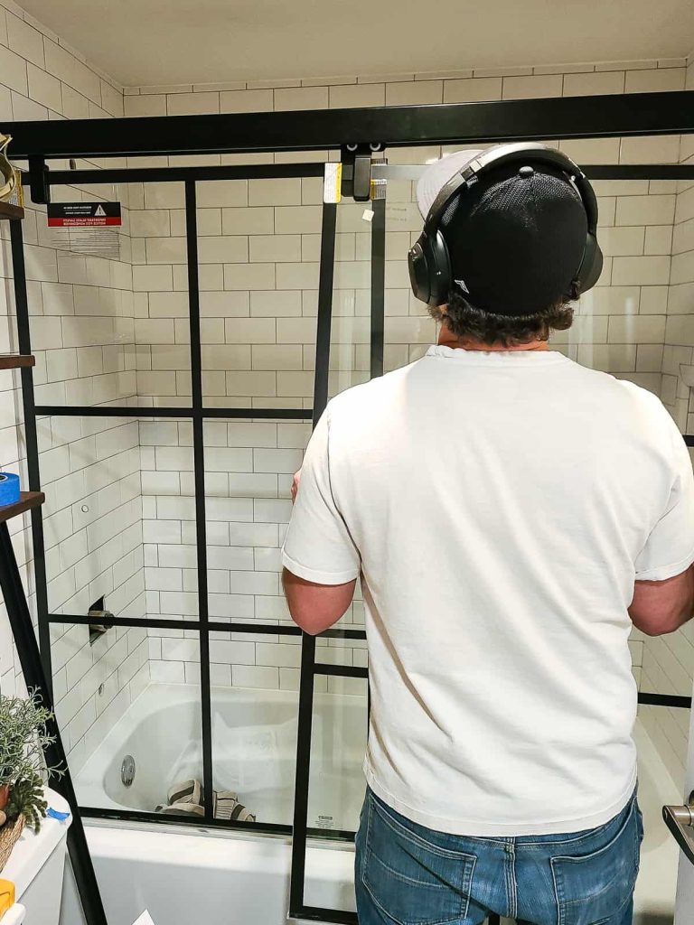 Hangin the doors as part of a how to install shower door tutorial for a bathroom in a tight space