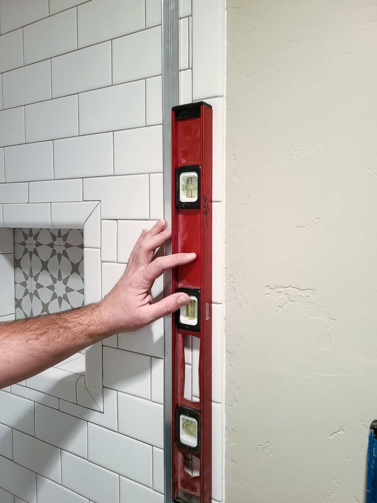 making sure the shower door is level using a template guide included in the shower door kit 