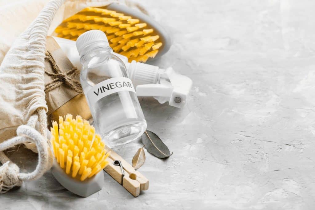 A picture with vinegar and other cleaning tools showing what you can use to make a mild cleaner for your cabinets