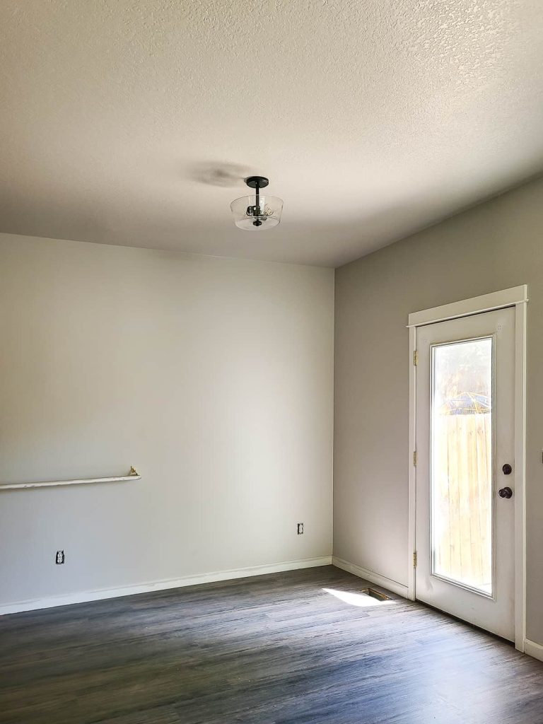 Completed ceiling light replacement with a new modern ceiling light in a dining room