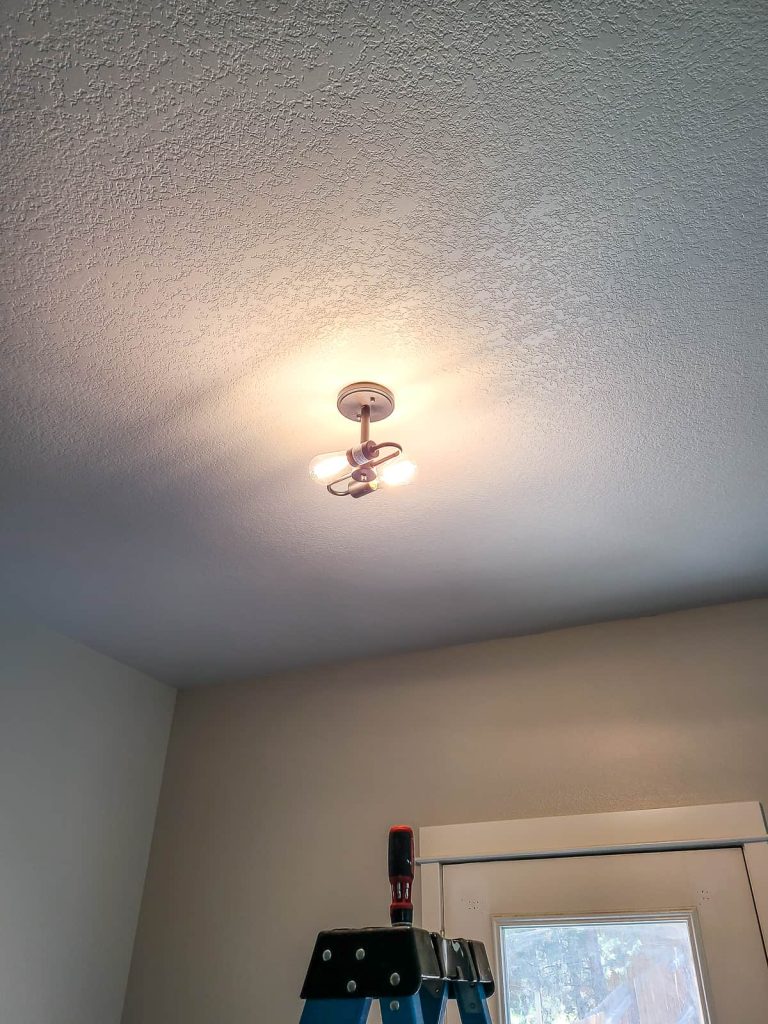 Showing new lights in a replaced ceiling light in a dining room testing the new light before finishing the install