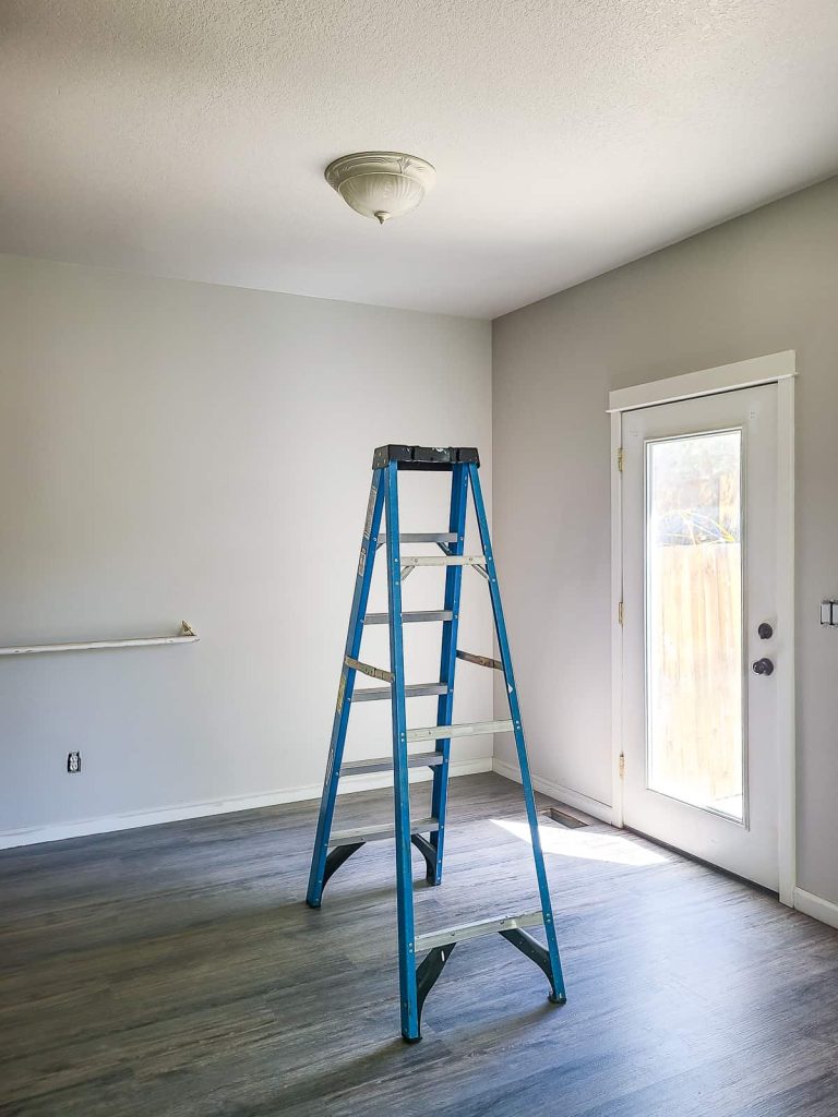 A boob light in a dining room as part of a how to replace a ceiling light tutorial with a ladder