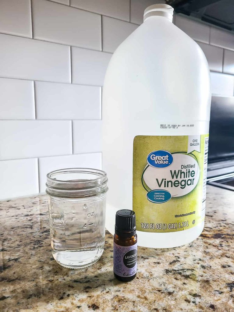 A picture with distilled white vinegar, lavender and 6 ounces of water to make a mild cleaner for cabinets