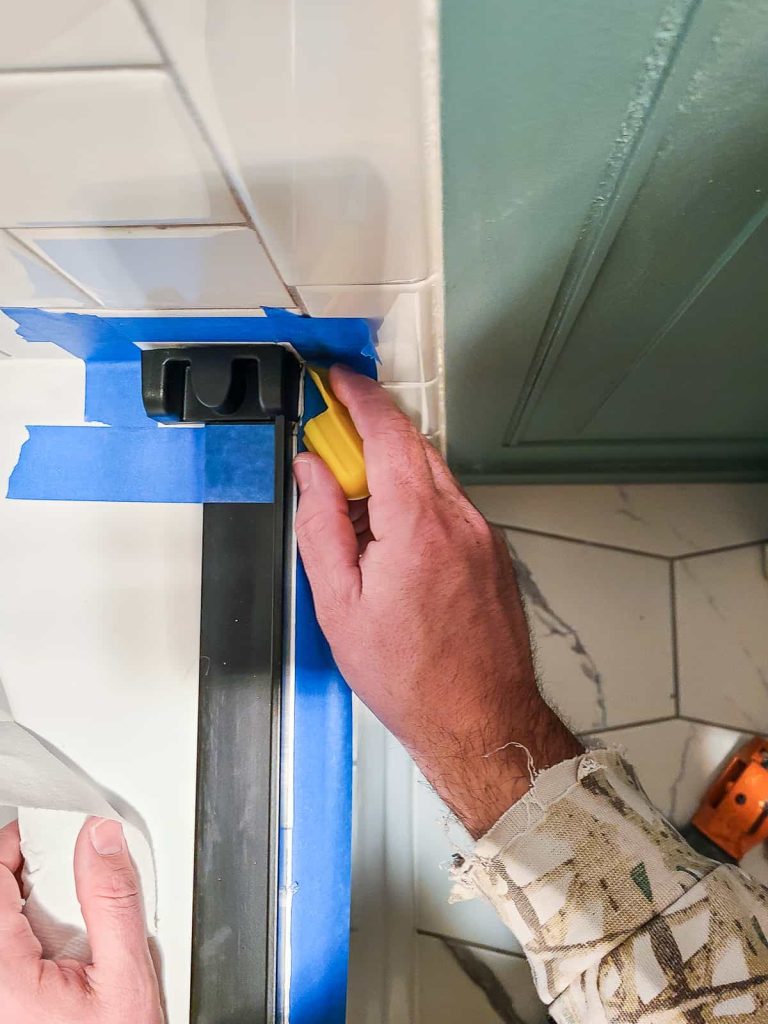Tooling the applied caulk with a Dap cap to create a neat and tidy water proof seal on the shower door install