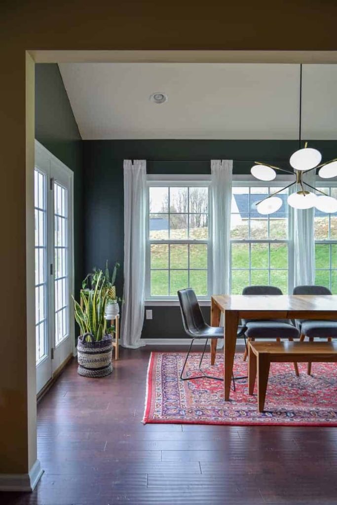 behr north woods color painted on the wall in a dining room with windows and dark wood floors