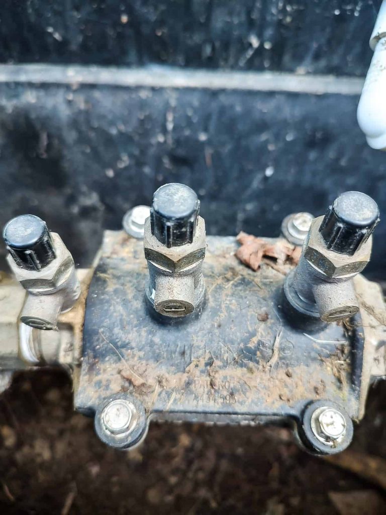 Close up picture of the test cocks on a vacuum breaker valve for turning on sprinkler system after winter