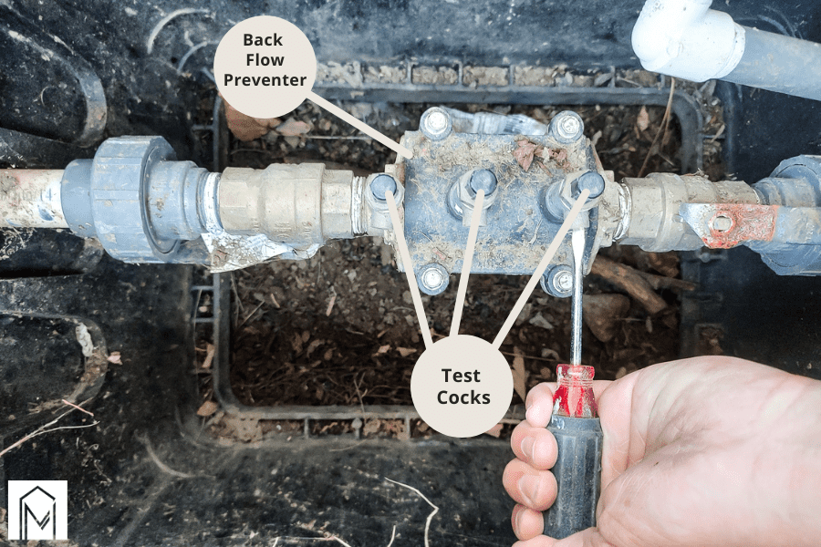 clearing out any debris that may be inside the backflow preventer valve by opening test cocks and allowing water to flow through