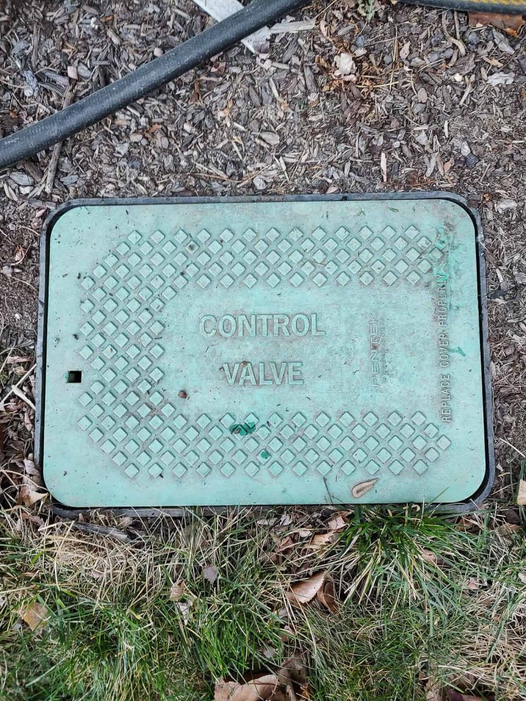 A green control box for a sprinkler system valve that also has a backflow preventer inside