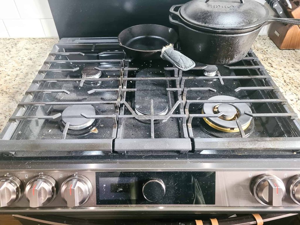 A dirty range that is part of a before picture for a how to clean a gas stove tutorial