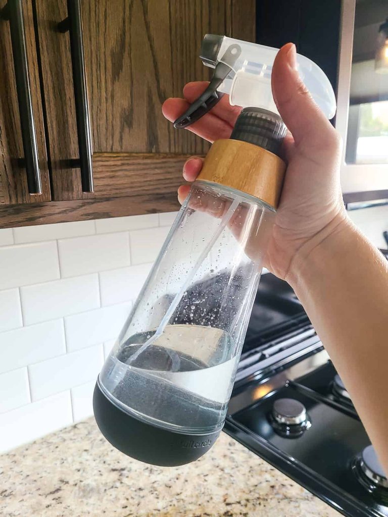 Homemade mild cleaner made from vinegar and lavender oil for how to clean kitchen cabinets in a glass bottle
