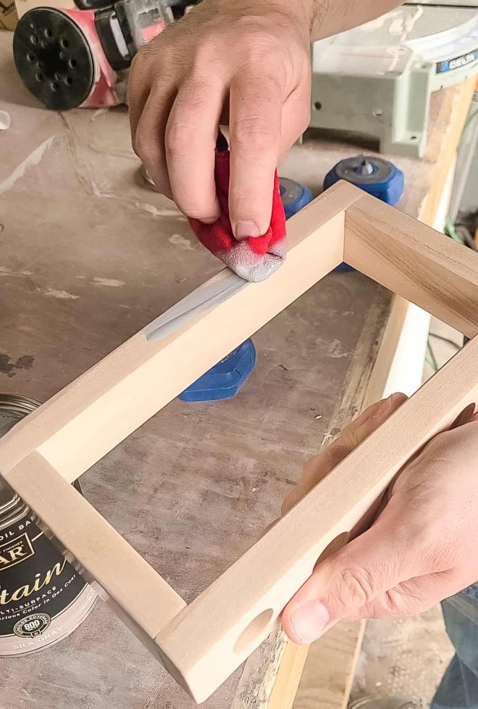 staining the diy propagation station with a grey stain and an old shirt to finish off the project
