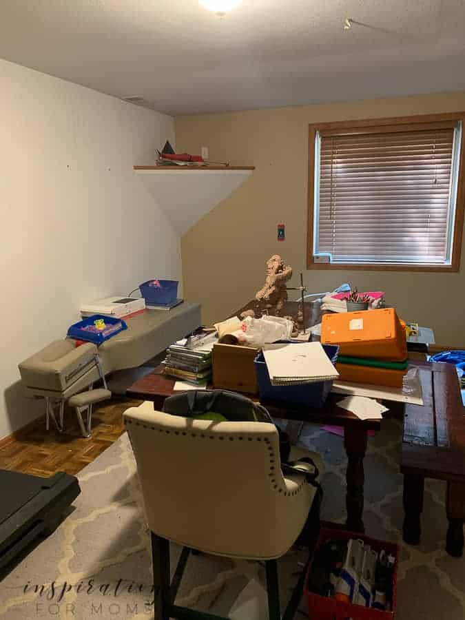 A cluttered office space with a random assortment of furniture and shelving showing a small space