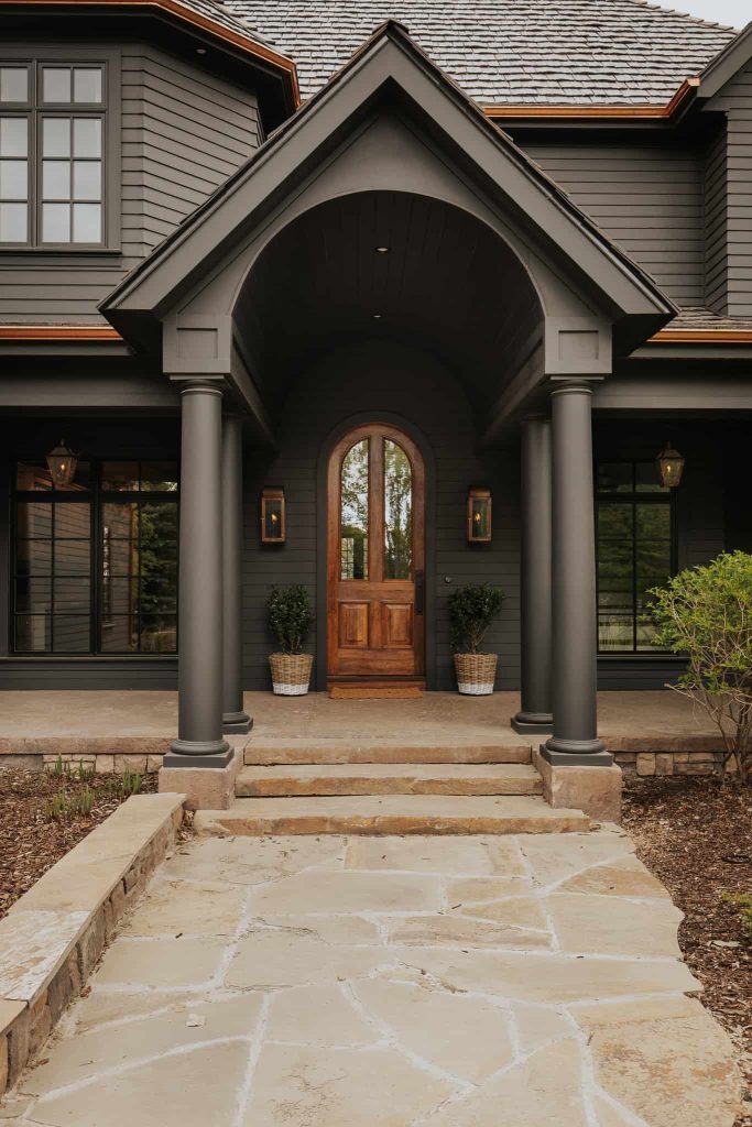 A natural wood door on a dark grey house is a great look and color that pairs well with grey colors