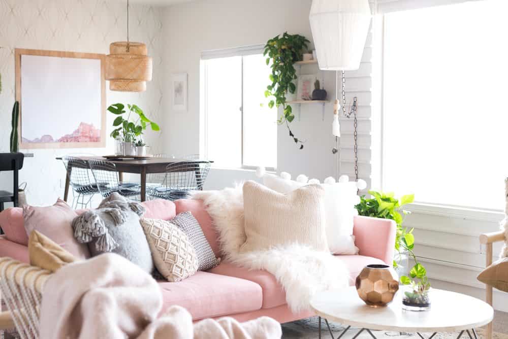 A pink couch with different style textures and patterns to mix and match pillows on a sofa
