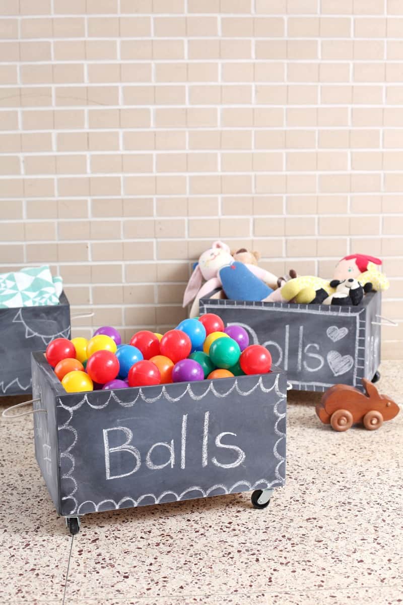 chalkboard painted crates on wheels for toy storage in living toom
