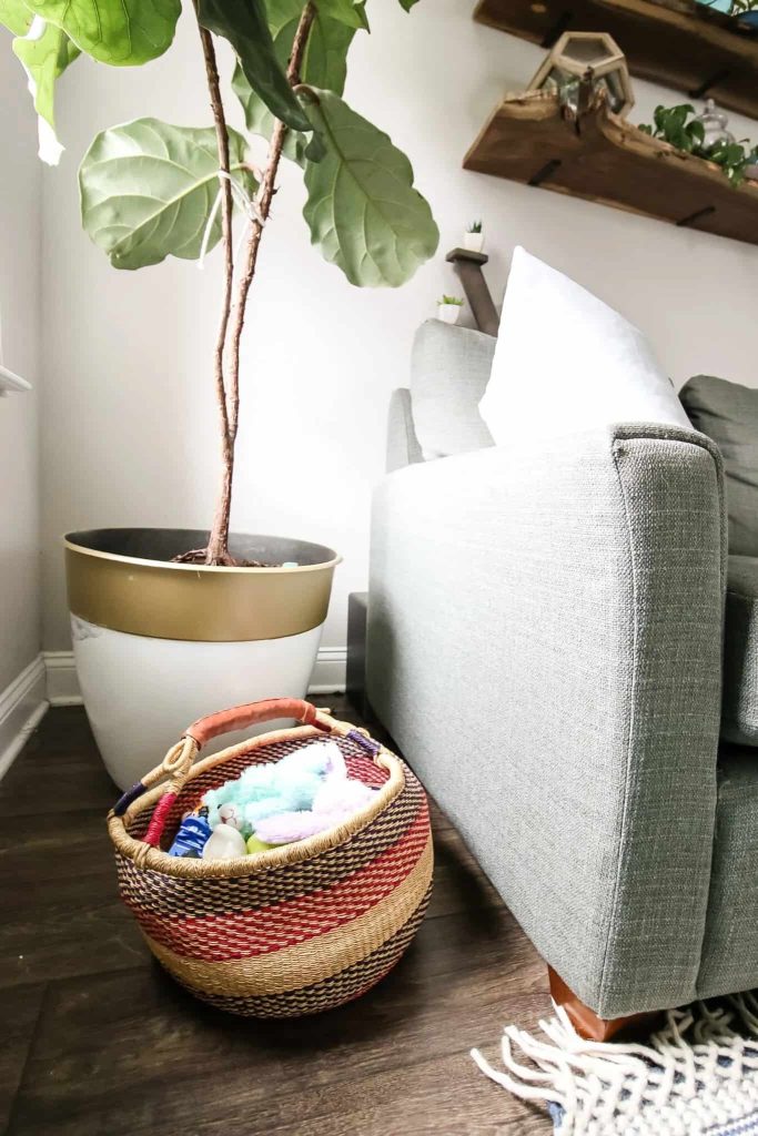 basket next to the sofa to store toys