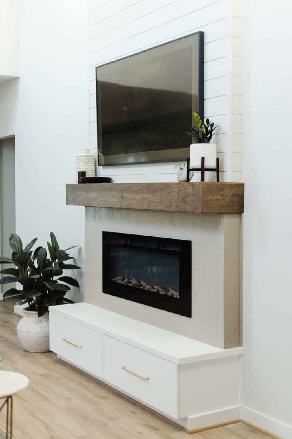 wall mounted fireplace with drawers underneath for toy storage in living room