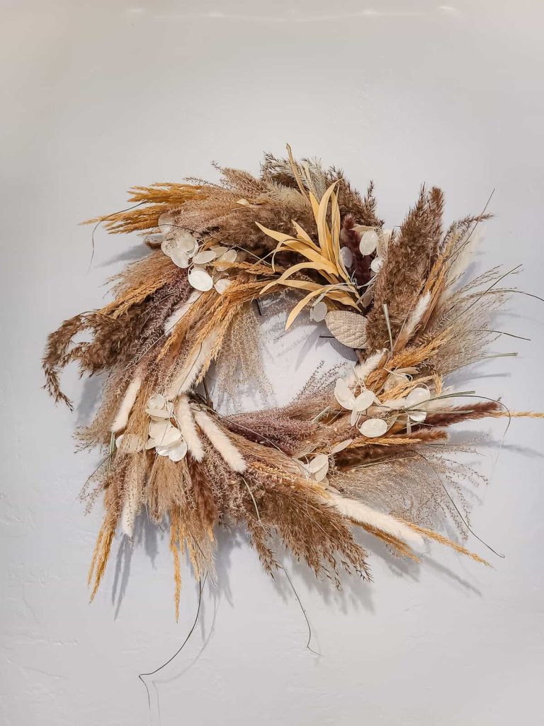 Another beautiful picture of boho style Pampas grass wreath hanging on the wall.