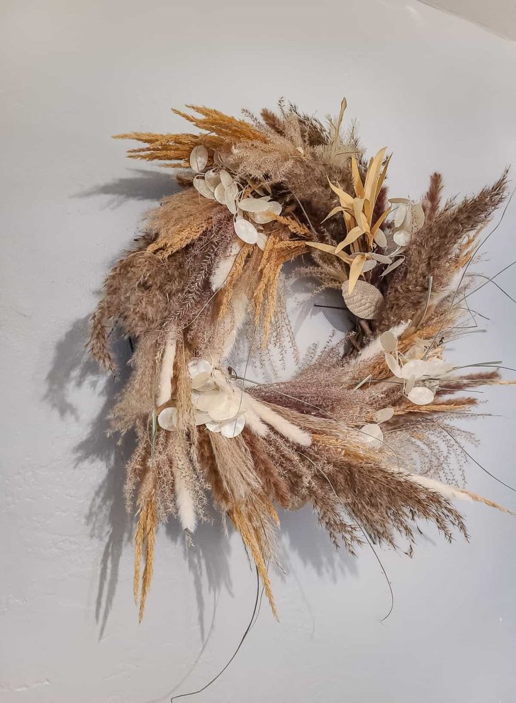A beautiful picture of Pampas grass wreath hanging on the wall.