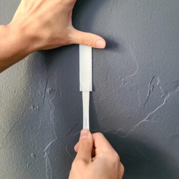 An image illustrating the proper way to remove Command Strips from walls, emphasizing damage-free removal.