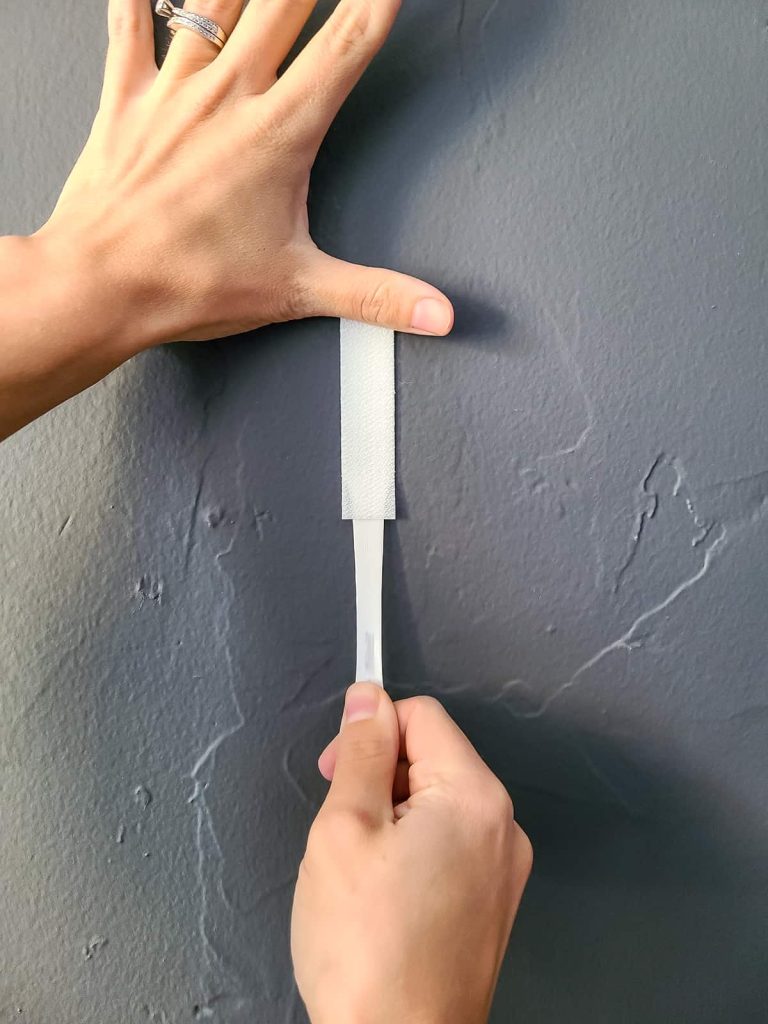 An image illustrating the proper way to remove Command Strips from walls, emphasizing damage-free removal.