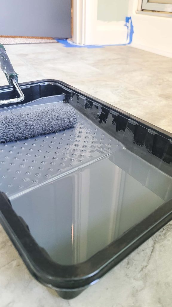 A roller brush filled with gray paint Graphic Charcoal from Behr paint