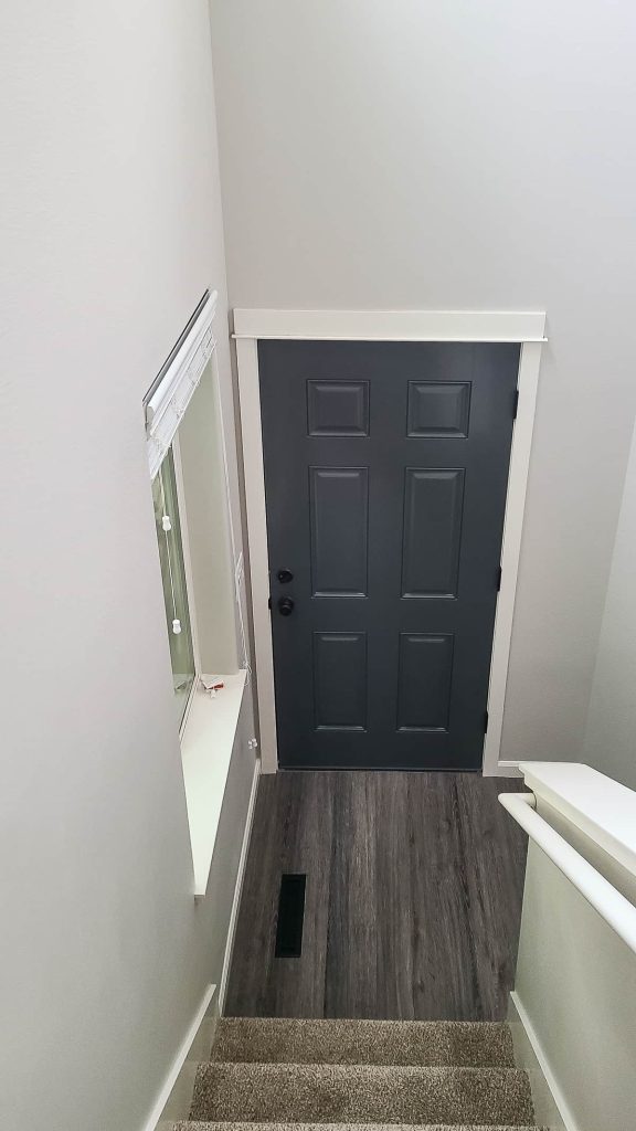 I love look of the inside of the front door painted this dark gray charcoal color, which is a great contrast to the light gray walls and white trim