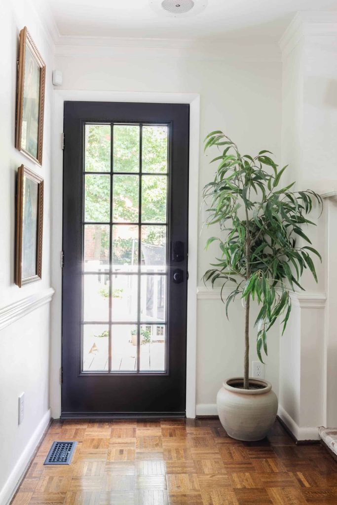 A photo of gorgeous French door painted black in the living space with white walls and trim with the door painted with Wrought Iron by Benjamin Moore
