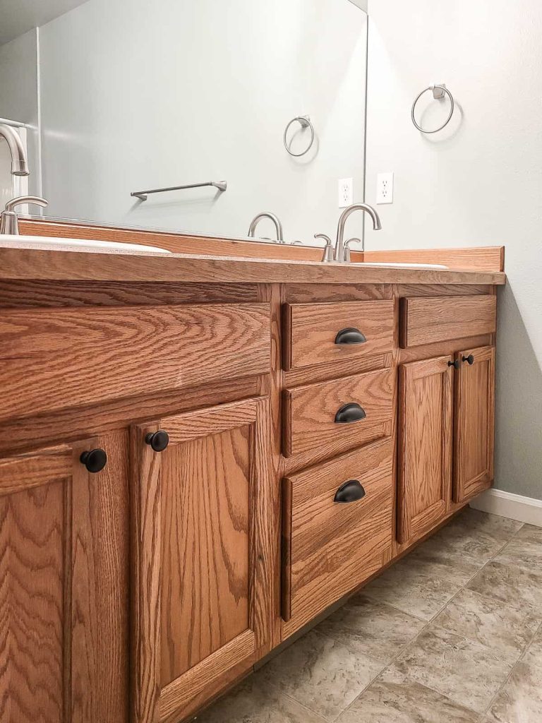 A close-up photo of a bathroom with a mirror, cabinet, and sink.