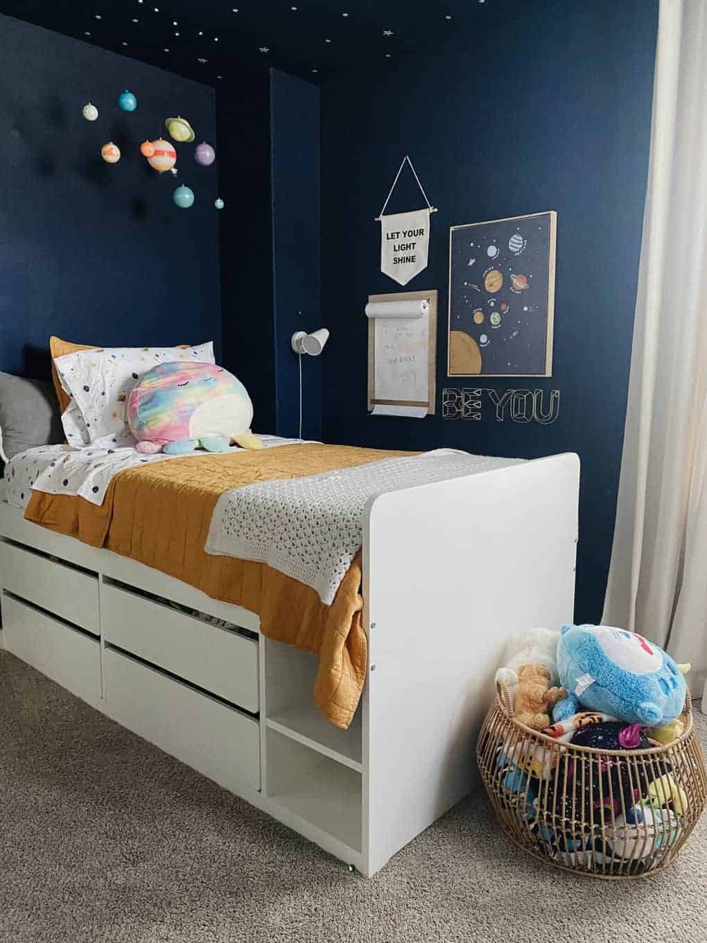 wire basket at the end of the bed for stuffed animal storage