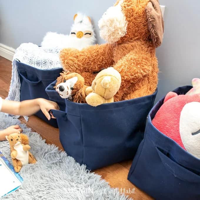 Stuffed animals stored in navy blue DIY fabric bins