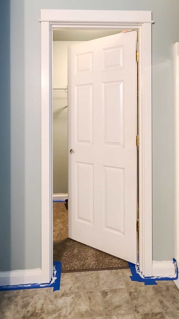 A photo of a door with no knob with trim painted with Swiss Coffee off white paint color from Behr Paint